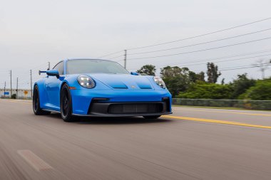 Hızlı bir Porsche GT3992 911 Carrera köpekbalığı mavi bir spor araba.