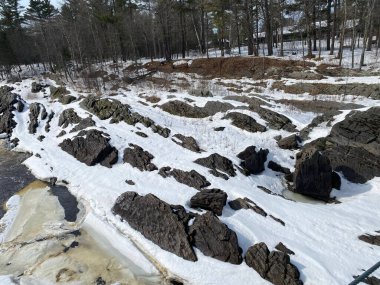 Soğuk kış gününde, ormanda karla kaplı Rocky nehri kenarı.