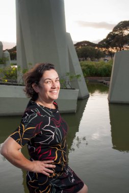 Güneşli bir günde parkta olgun bir bayan arka planda kristallerle eğleniyor.