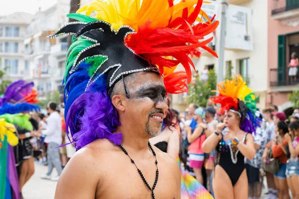 2022年6月12日スペイン シッジズでゲイのプライドイベントを祝うカラフルな羽の帽子で顔を描いた笑顔の男 — ストック写真