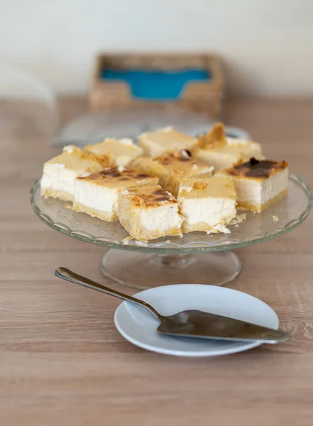 テーブルの上に白いプレートと自家製チーズケーキのスライスの垂直閉鎖ショット — ストック写真