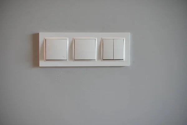 白い壁に白いライトスイッチのクローズアップショット — ストック写真