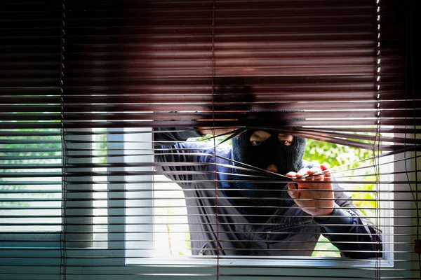 Siyah Maskeli Bir Hırsız Panjurların Arasından Gizlice Bakıyor — Stok fotoğraf