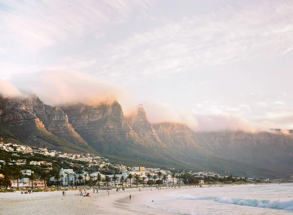 Mensen Een Zandstrand Met Huizen Rotsachtige Bergen Achtergrond Zuid Afrika — Stockfoto