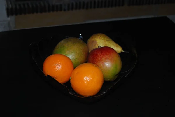 Primer Plano Dos Naranjas Dos Mangos Una Pera Tazón Negro —  Fotos de Stock