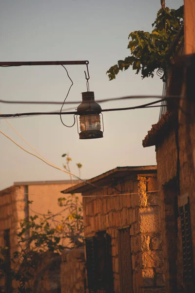 Вертикальный Снимок Уличной Лампы Свисающей Шеста Фоне Старых Зданий Неба — стоковое фото