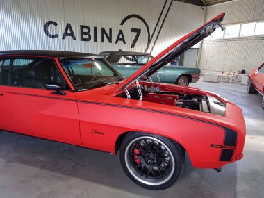 Eski kırmızı spor Chevrolet Camaro LS7 Coupe 1969 model GM bir depoda. Kaputu aç. Motor. Klasik kaslı araba. Fierro Fuarı 2022.