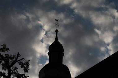Bulutlu bir geçmişi olan bir kilise kulesi.