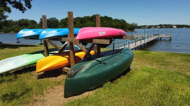 Göl kenarında ağaçların arkasına park edilmiş renkli kano manzarası