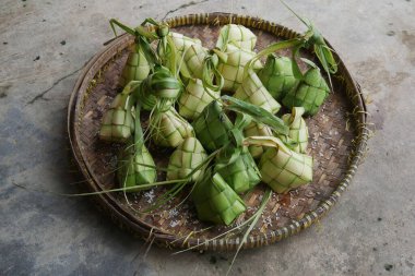 Ketupat manzarası. Elmas şeklindeki bir konteynır dolusu palmiye yaprağı kesesinde paketlenmiş bir Java pirinç keki.,
