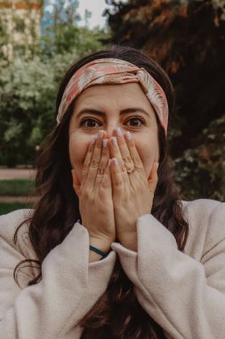 Baharda bir parkta duygularını gösteren güzel bir İspanyol kızın portresinin dikey çekimi.