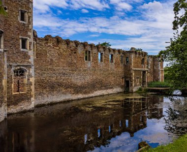 Caister Kalesi 'nin kalıntıları bir hendekte, bir tarlada yeşilliklerle çevrili.