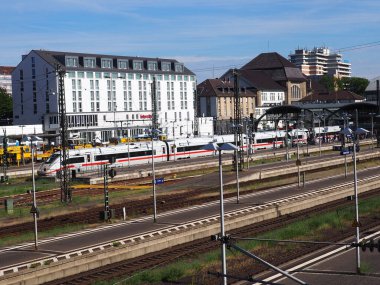 Güneşli bir günde arka planında binalar olan Darmstadt istasyonunda ICE treni