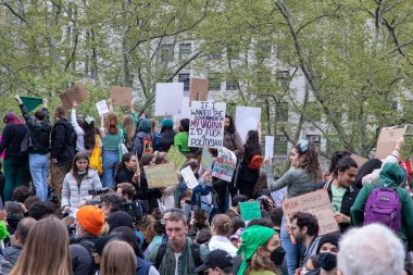 A young Female holding a cardboard sign with the words 