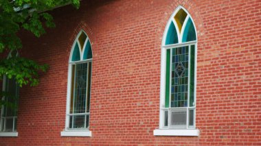 Kırmızı tuğlalı duvardaki dekoratif kavisli pencereler.