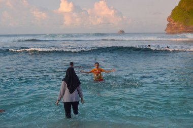 Sahilde turistlerin oynadığı plaj manzarası. Mekan Goa, Çin, Malang, Doğu Java sahillerinde.