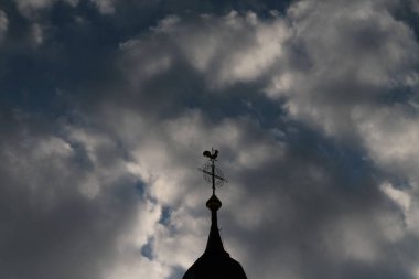 Bulutlu bir geçmişi olan bir kilise kulesi.