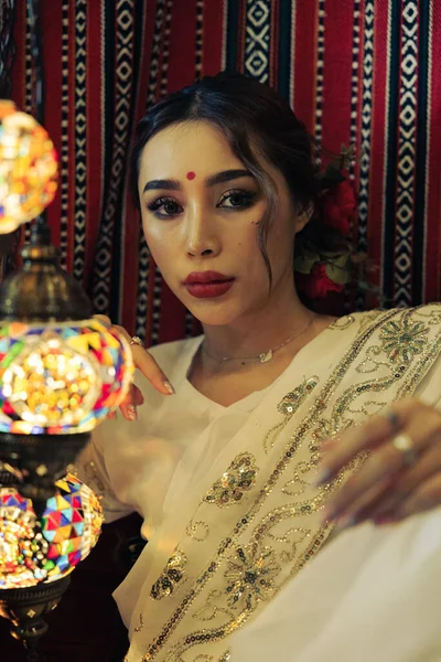 Güney Asyalı bir kızın kırmızı duvara karşı dikey görüntüsü.