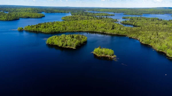濃い青の海の緑の森に覆われた複数の島の空中ショット — ストック写真