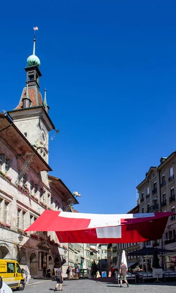 スイスのローザンヌのダウンタウンにある大きなスイスの旗と時計塔 — ストック写真