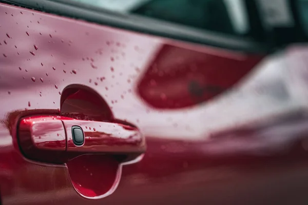 红色汽车门把手的特写 带有新鲜雨滴 — 图库照片