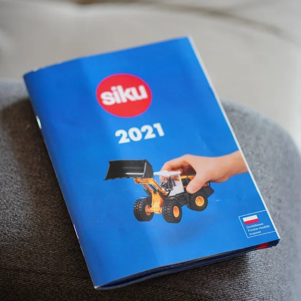 グレーのソファにおもちゃで2021年から閉鎖的な青のSikuブランドのパンフレットのクローズアップショット — ストック写真