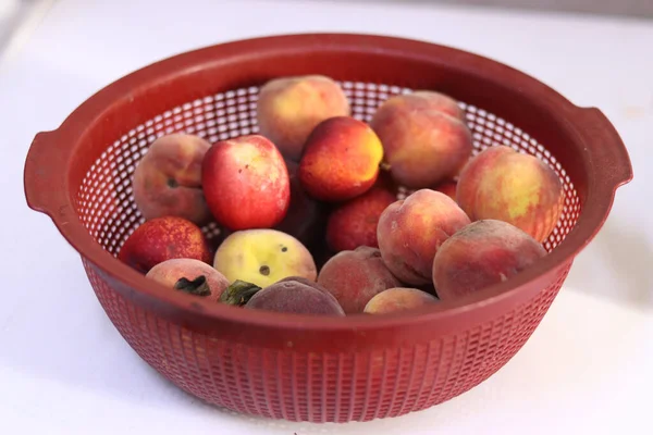 白いテーブルの上のボウルに赤桃とネクタリン — ストック写真