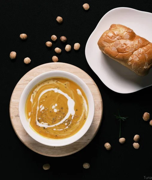 黒テーブルの上にパンとカボチャのスープの垂直方向のトップビュー — ストック写真