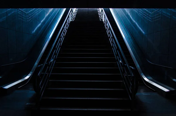 近代的な地下鉄駅の両側にエスカレーターと暗い階段 — ストック写真