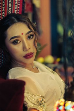 Bulanık arkaplanda Güney Asyalı bir kadının dikey çekimi.