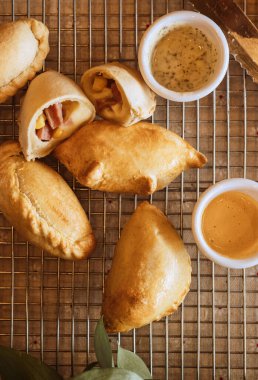 Taze panzerotti ve mutfak ağındaki sosların üst görüntüsü.