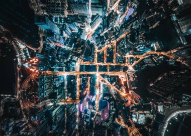 Geceleyin Hong Kong, Çin 'de ışıklarla ve modern gökdelenlerle çevrili işlek otoyolların nefes kesici bir görüntüsü.