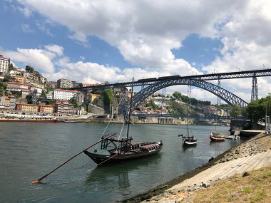 Rabelo tekneleri Porto, Portekiz 'deki bir köprünün yanındaki Douro Nehri rıhtımına demirledi.