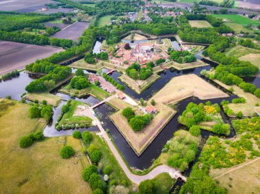 Gündüz vakti ağaçlar ve su kanallarıyla Bourtange Kalesi 'nin dizaynının insansız hava aracı görüntüsü.
