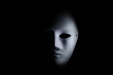 Siyah arka planda korkunç beyaz bir maskenin yarısı.