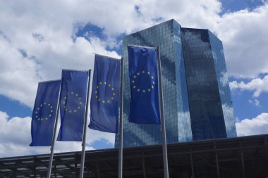 Frankfurt, Almanya 'daki Avrupa Merkez Bankası genel merkezinin önünde Avrupa bayrakları dalgalanıyor. Mavi gökyüzüne karşı mavi.