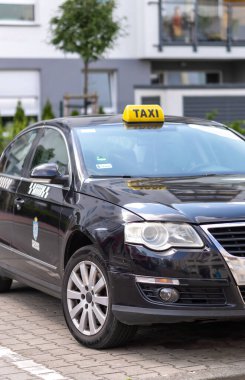 Poznan, Polonya 'nın Stare Zegrze bölgesindeki park yerinde park etmiş siyah bir taksi.