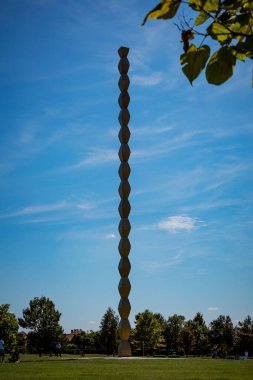Sonsuz Sütun 'un dikey çekimi (Coloana Inifitului) mavi gökyüzüne karşı heykel