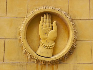 Duvarda bir Hindu tanrısı el falı heykeli var.