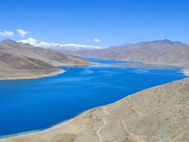 Tepeler arasında akan mavi bir nehrin manzarası açık gökyüzü arka planında kırsal bir alanda