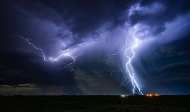 Fırtınalı bir gecede, küçük bir köyün yakınındaki çimenli bir arazide, gece gökyüzünde güzel bir yıldırım çarpması.