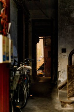 Konut binasının karanlık koridorunun sonunda açık bir kapı, dikey.