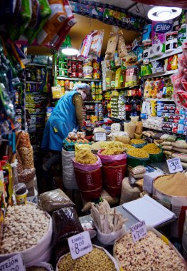 Arequipa, Peru 'daki Mercado San Camilo gıda pazarında çalışan bir kadının dikey çekimi.