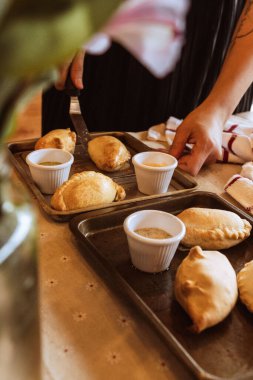 Mutfak çarşafında bir kase sosla taze panzerotti 'nin dikey yakın çekimi.