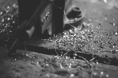 Endüstriyel bir makinenin seçici odak noktası gri ve tahta bir yüzey üzerindeki metal parçaları