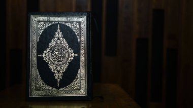 Kuran-Müslümanların kutsal kitabının ahşap bir masanın üzerindeki yakın plan fotoğrafı.