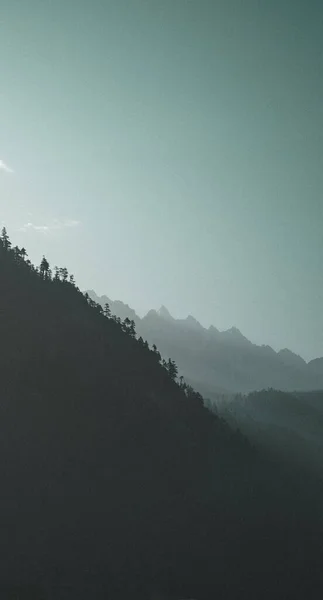 霧の中で山のシルエットの垂直ショット — ストック写真