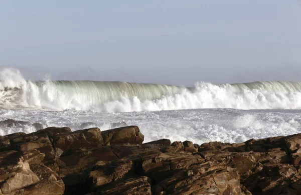 Güney Afrika 'nın Garden Route' undaki Mossel Körfezi 'nde kayalara çarpan dalgalar.