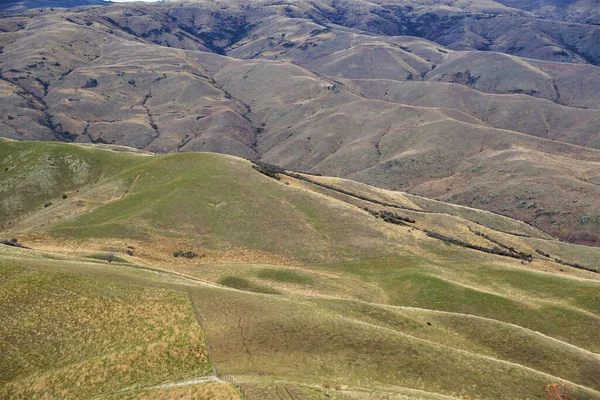 在有弯曲的绿色斜坡的山丘上拍的无人驾驶飞机照片 — 图库照片