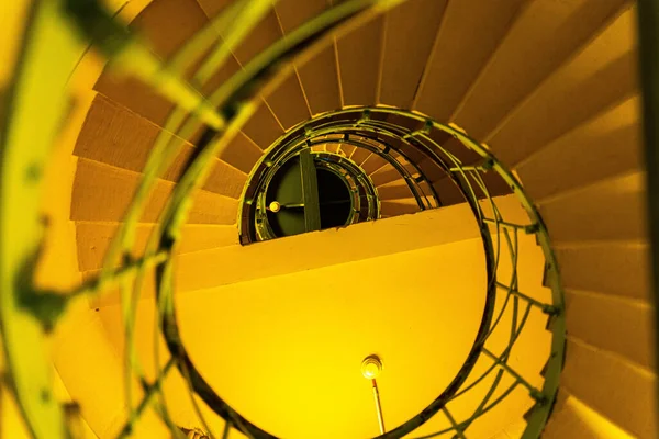 金属製の手すりのある黄色の螺旋階段の上からの眺め — ストック写真